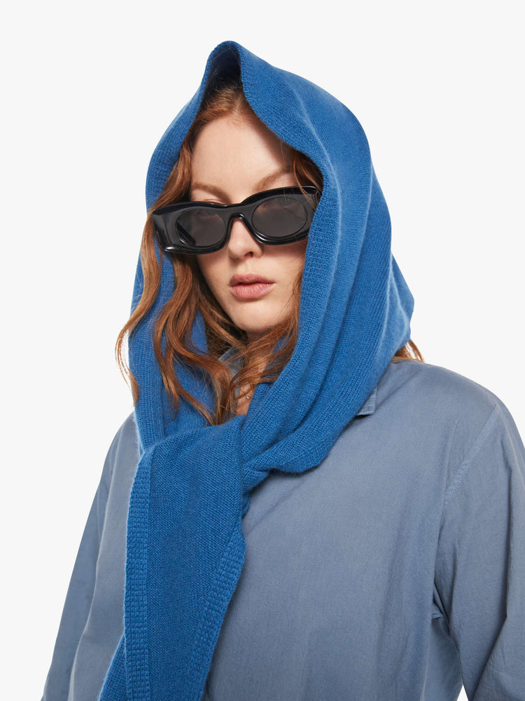 On model view of a model in a cashmere blue scarf features a triangular silhouette with tapered ends.