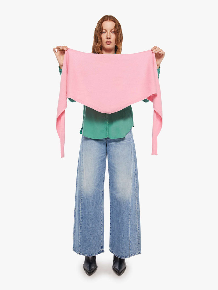 Front view of a woman in a cashmere  bubblegum pink scarf features a triangular silhouette with tapered ends.