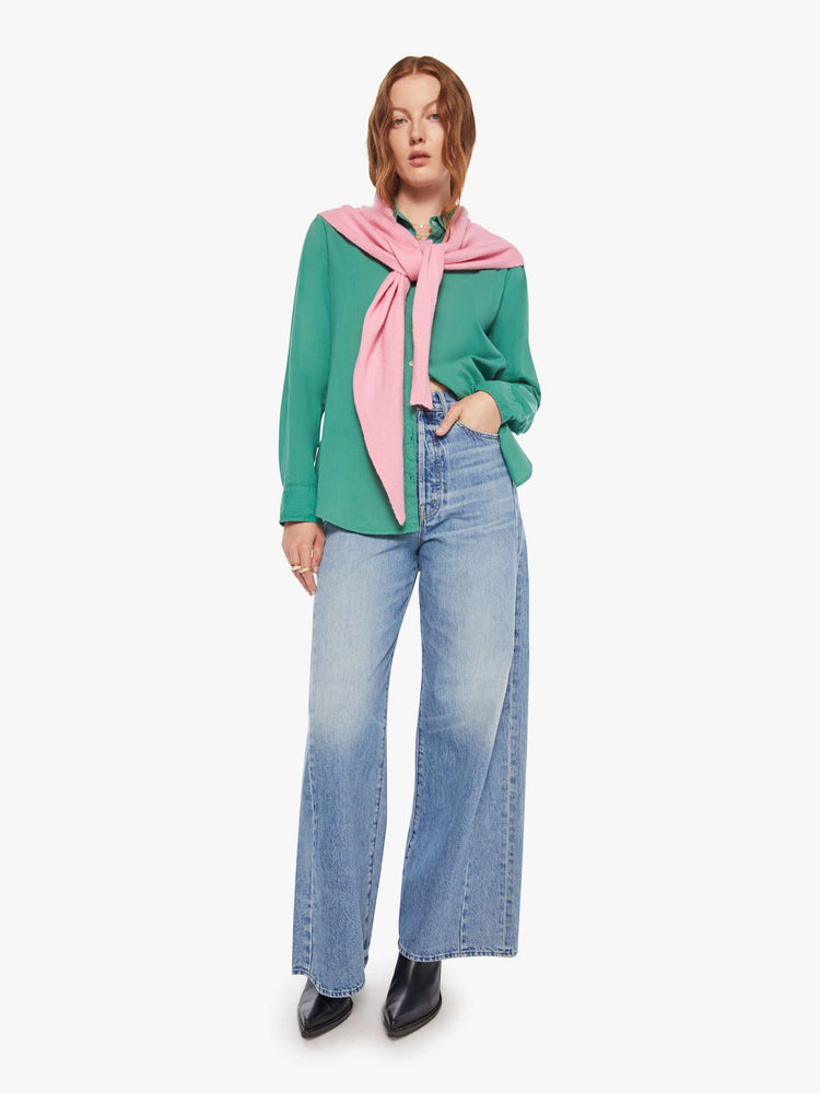 Full body view of a woman in a cashmere  bubblegum pink scarf features a triangular silhouette with tapered ends.