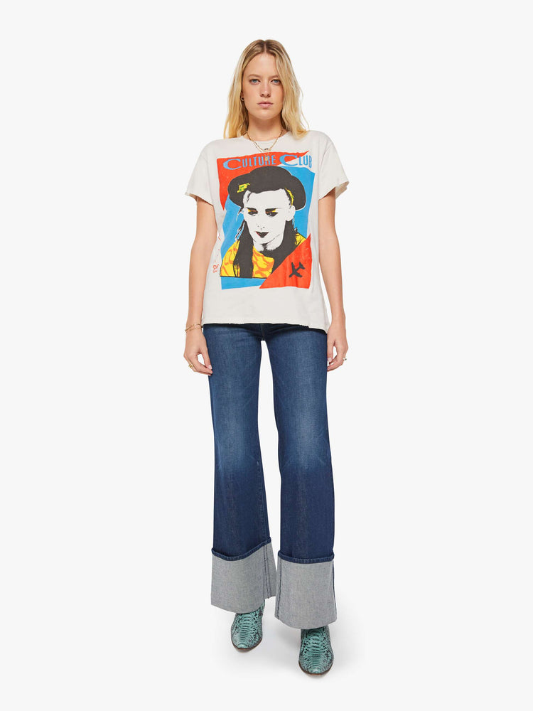 Full body view of a woman in a white tee pays homage to Culture Club with a colorful portrait on the front.