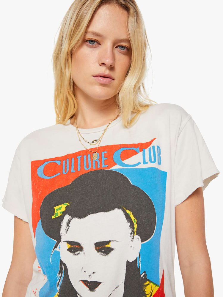 Close up view of a woman in a white tee pays homage to Culture Club with a colorful portrait on the front.