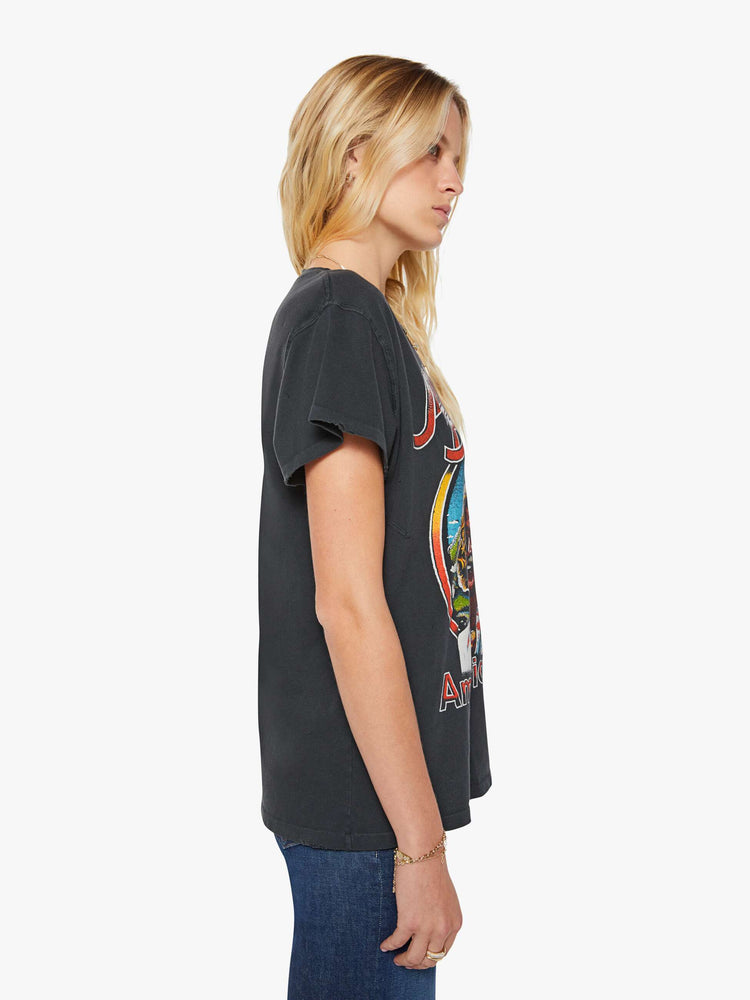 Side view of a woman in a black tee is inspired by Jimmy Buffett's American tour merch with a graphic portrait on the front.