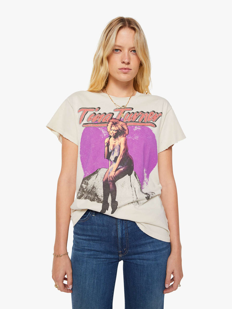 Front view of a woman in a cream tee pays homage to Tina Turner with a graphic portrait on the front.