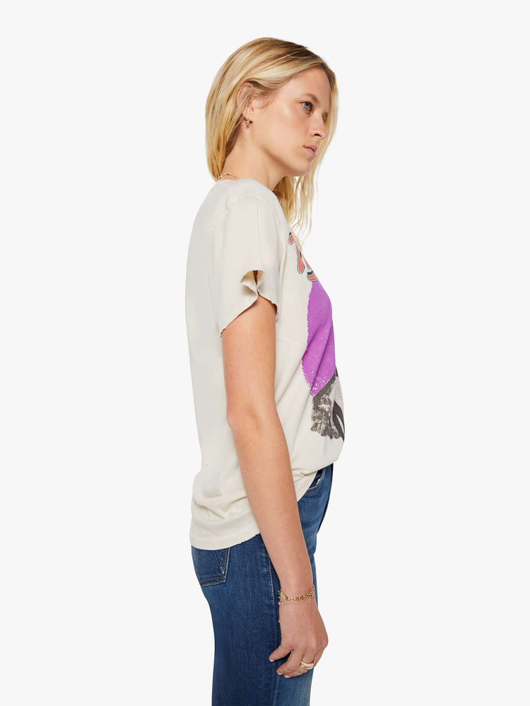 Side view of a woman in a cream tee pays homage to Tina Turner with a graphic portrait on the front.