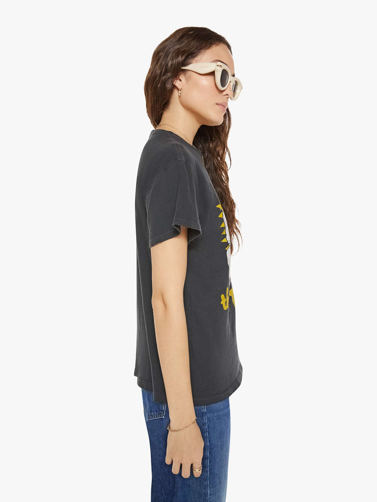 Side view of a woman in a black tee that pays homage to the B-52's with a graphic portrait on the front.