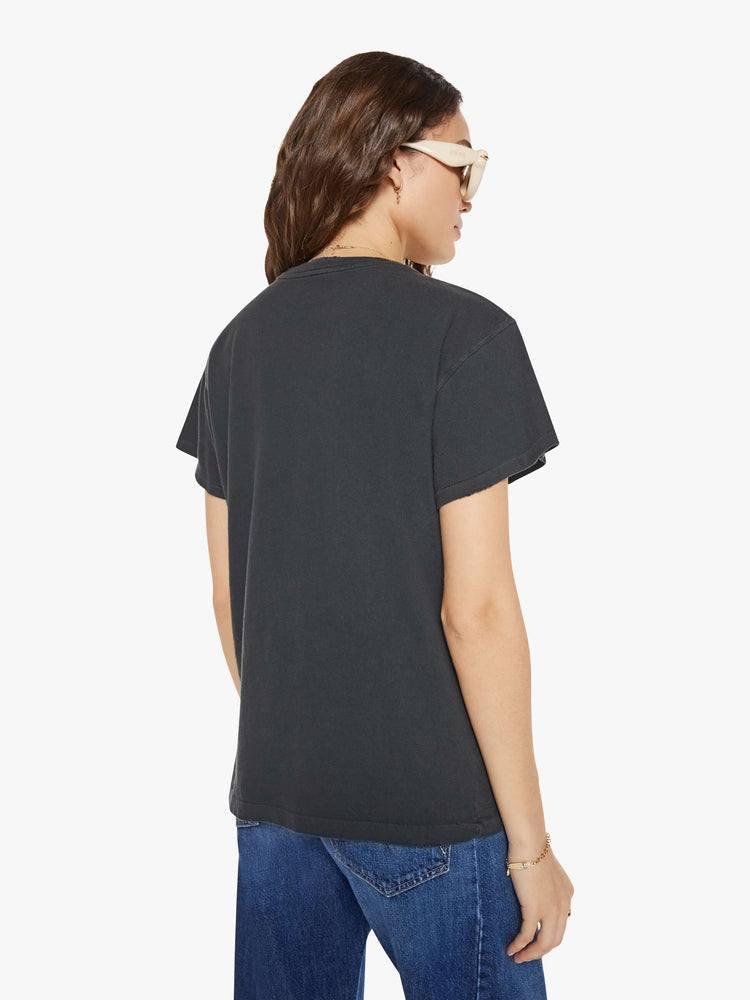 Back view of a woman in a black tee that pays homage to the B-52's with a graphic portrait on the front.