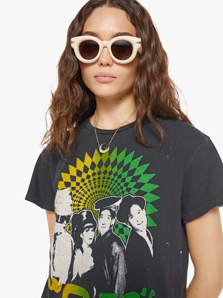 Close up view of a woman in a black tee that pays homage to the B-52's with a graphic portrait on the front.