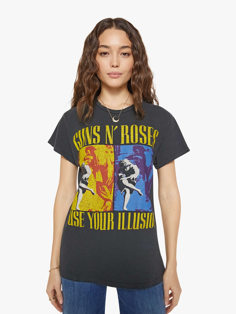 Front view of a woman in a black tee that homage to Guns N' Roses with a graphic portrait and text in yellow on the front.