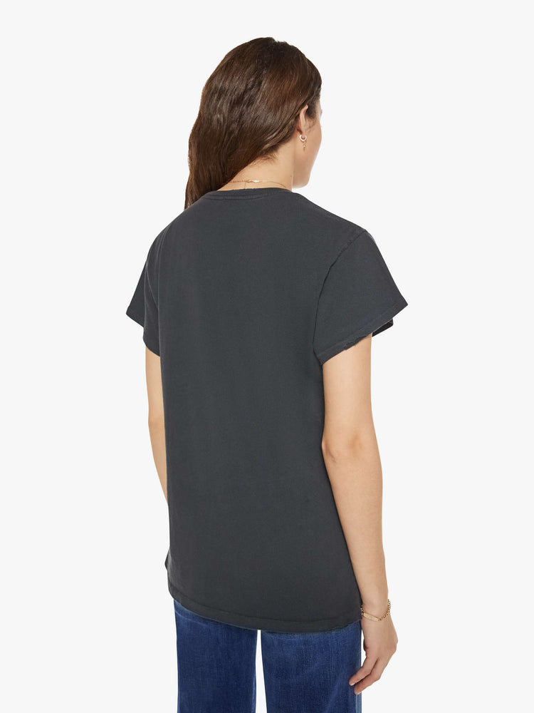 Back view of a woman in a black tee that homage to Guns N' Roses with a graphic portrait and text in yellow on the front.