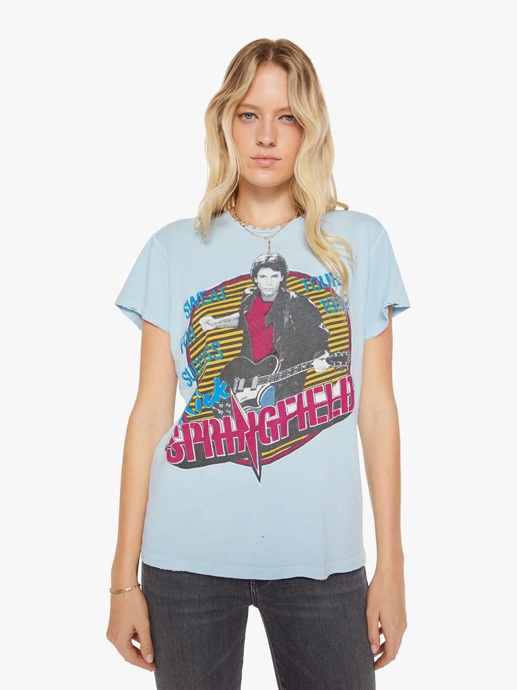 Front view of a woman in a blue tee with a Rick Springfield with a graphic portrait on the front and back.