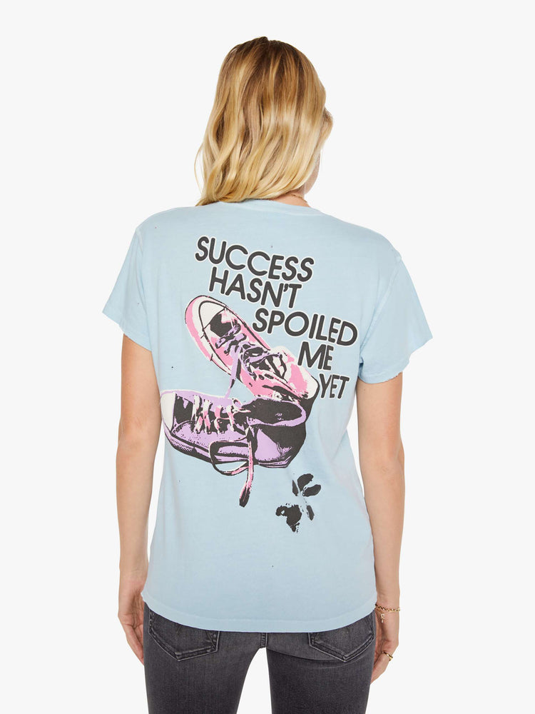 Back view of a woman in a blue tee with a Rick Springfield with a graphic portrait on the front and back.