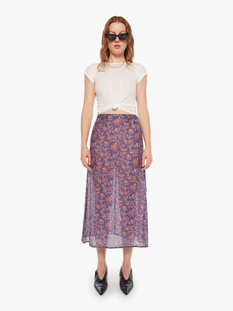 Front view of woman in  blue and pink floral print midi skirt has a high rise, calf-length hem and a loose, flowy fit.