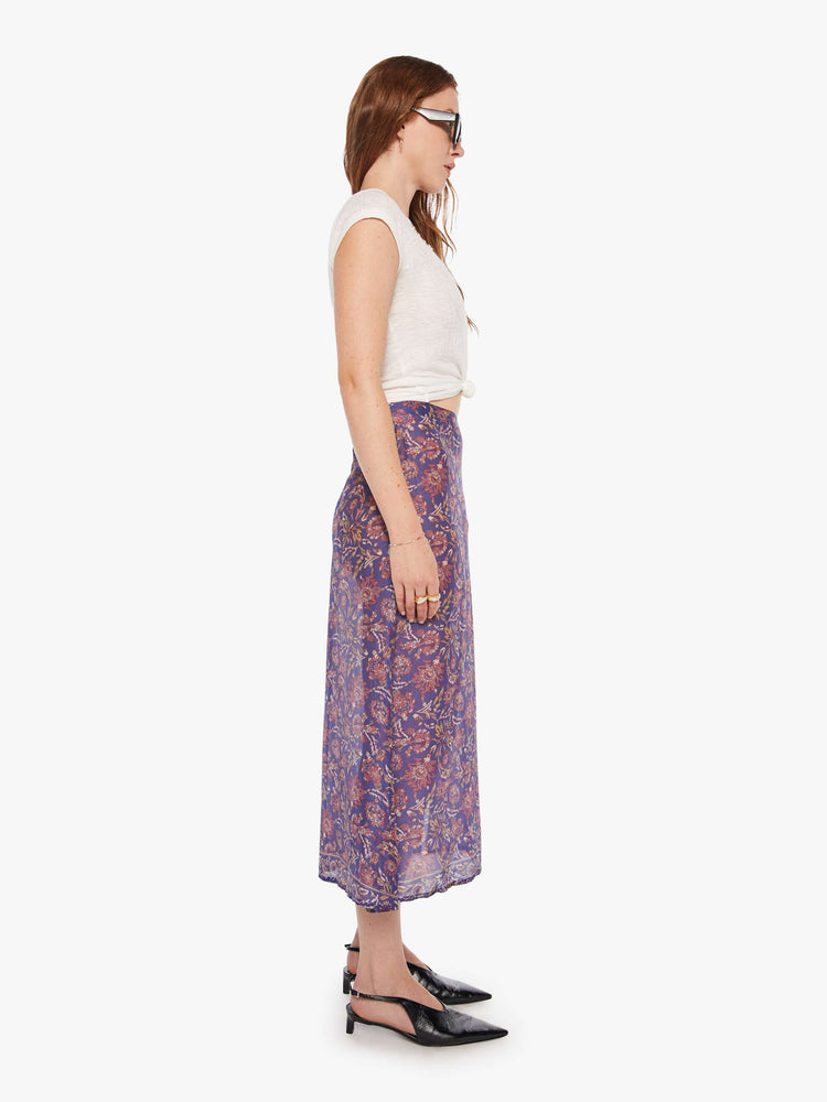 Side view of woman in  blue and pink floral print midi skirt has a high rise, calf-length hem and a loose, flowy fit.
