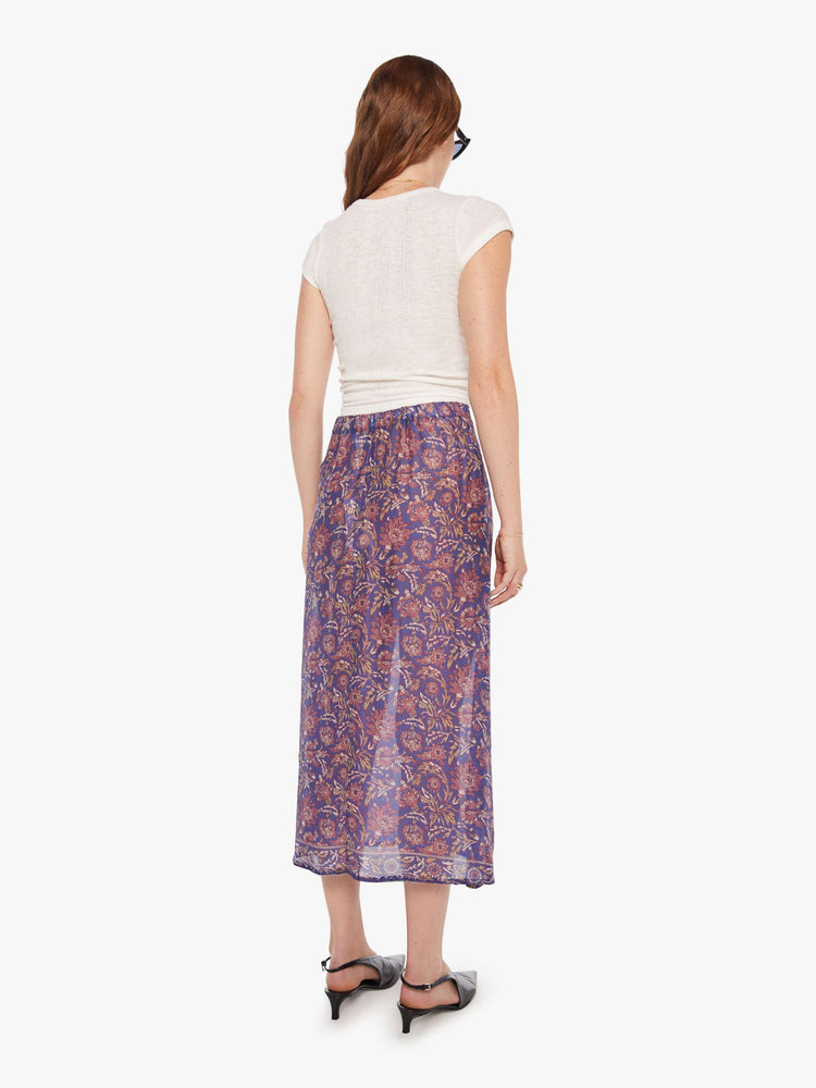 Back view of woman in  blue and pink floral print midi skirt has a high rise, calf-length hem and a loose, flowy fit.