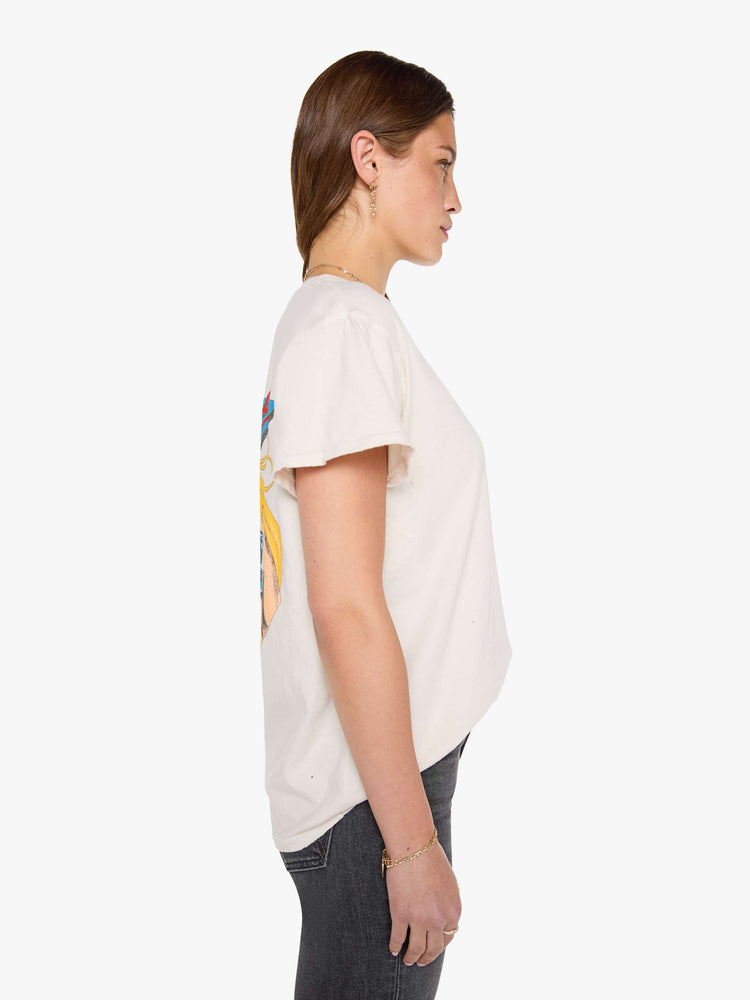 Side view of a woman in a off-white tee pays homage to The Beach Boys with a colorful graphic on the front and back.