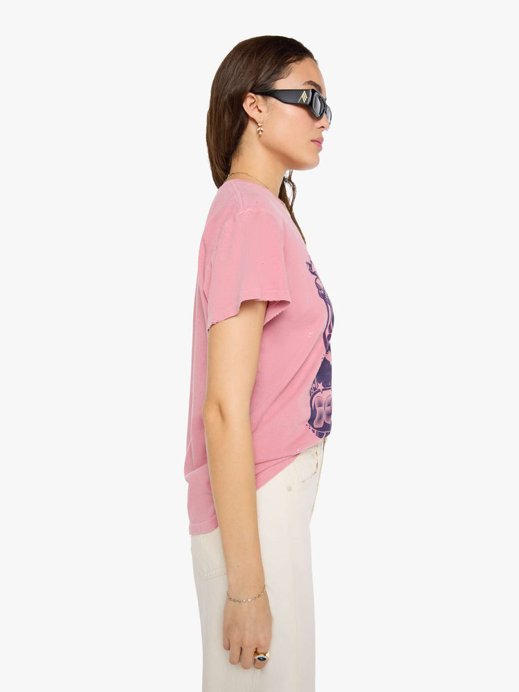 Side view of a woman in pink tee pays homage to The Beatles with a graphic portrait and text in blue on the front.