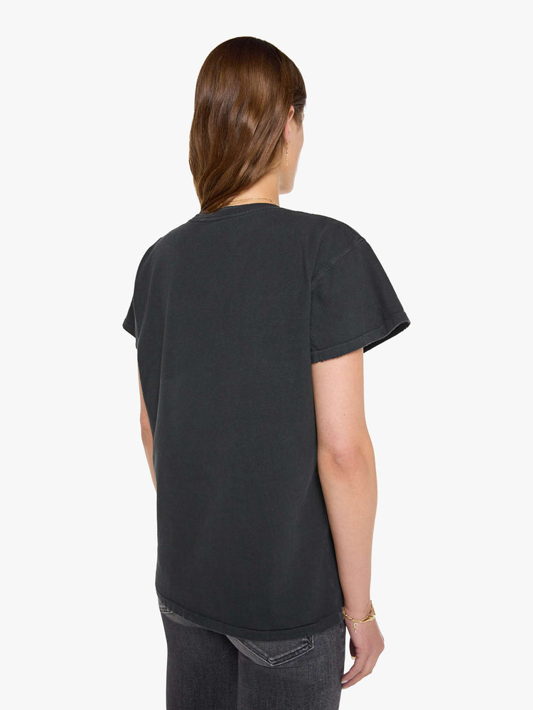 Back view of a woman in black tee honors Bauhaus with a graphic portrait in cream on the front.