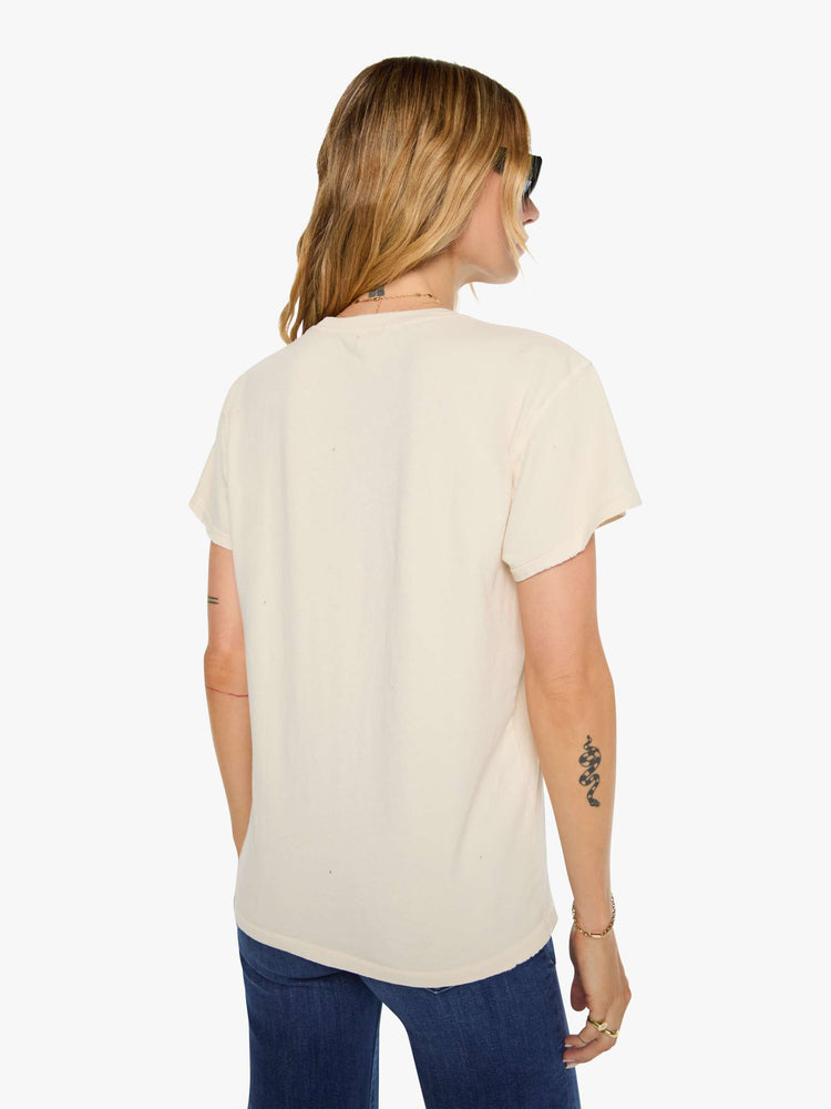 Back view of a woman in a tan tee pays homage to Stevie Nicks with a colorful portrait on the front.