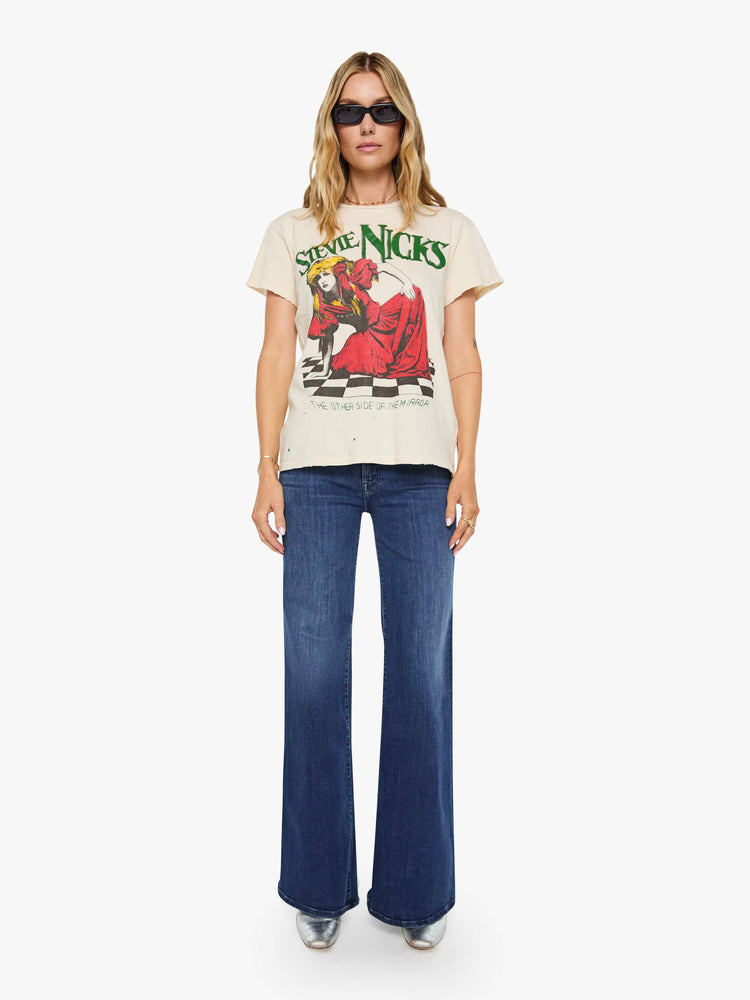 Full body view of a woman in a tan tee pays homage to Stevie Nicks with a colorful portrait on the front.