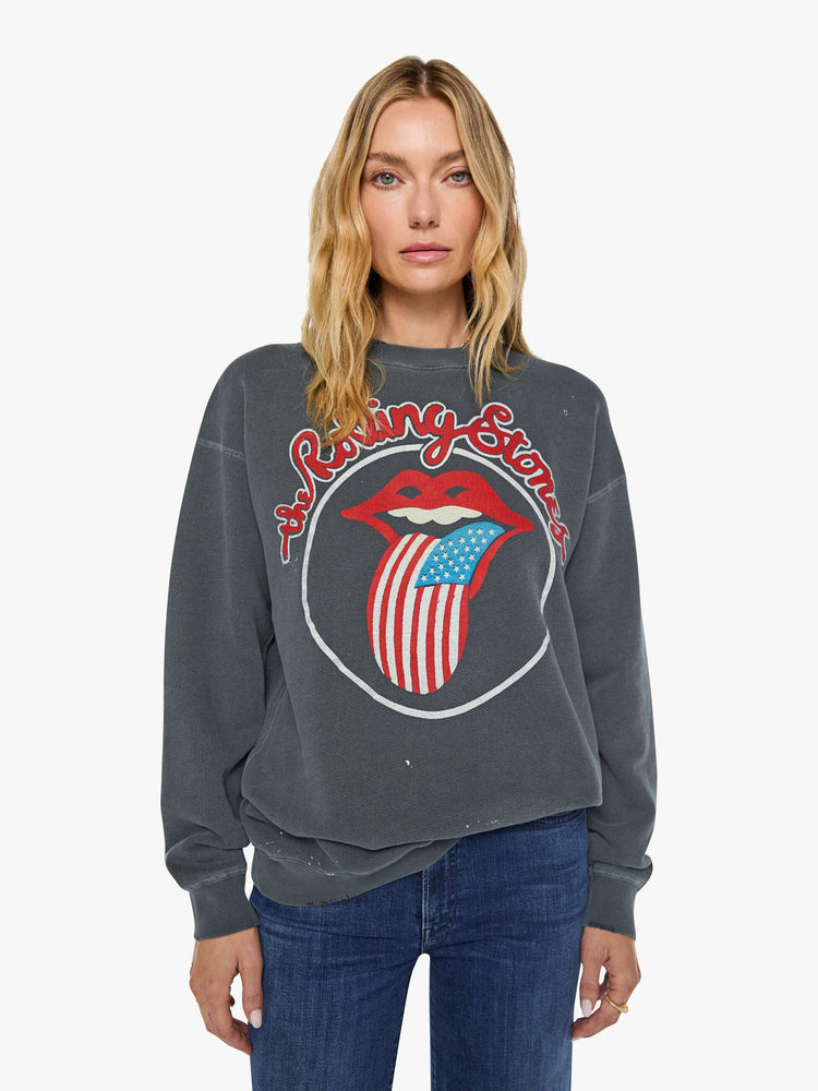 Front view of a woman in dark grey sweatshirt pays homage to The Rolling Stones with the band's iconic tongue graphic on the front.
