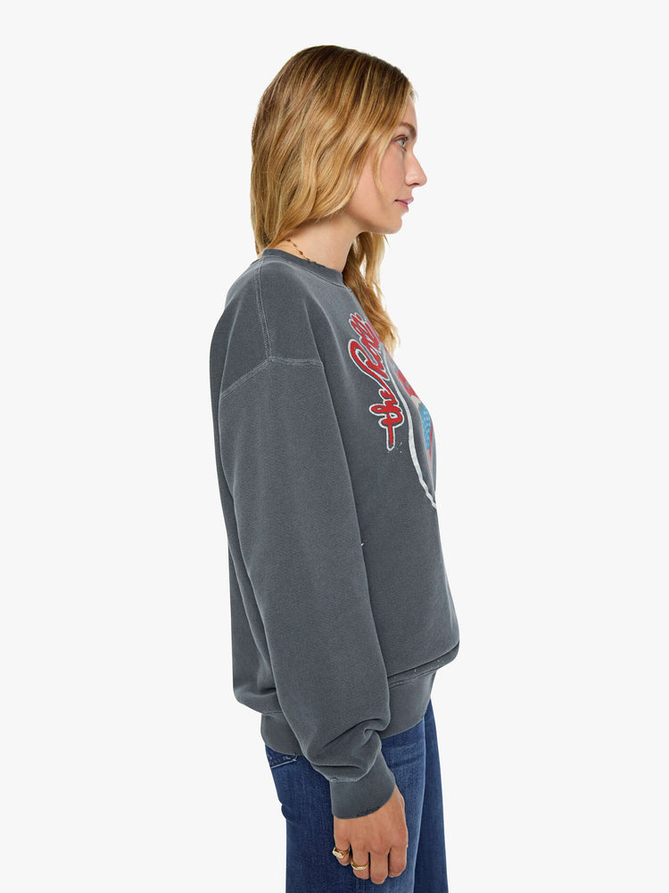 Side view of a woman in dark grey sweatshirt pays homage to The Rolling Stones with the band's iconic tongue graphic on the front.