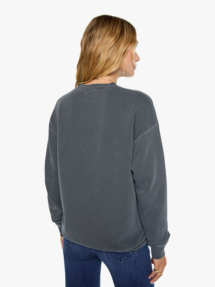 Back view of a woman in dark grey sweatshirt pays homage to The Rolling Stones with the band's iconic tongue graphic on the front.