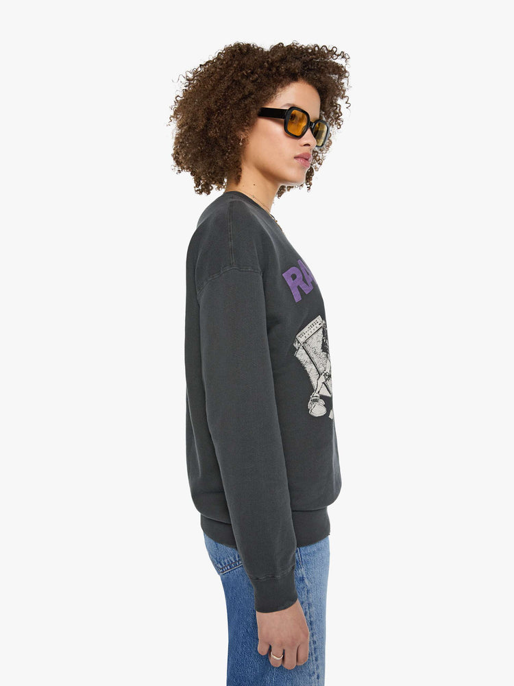 Side view of a woman in a faded black sweatshirt pays homage to The Ramones' eleventh studio album with a cream graphic and the band's name in purple on the front.