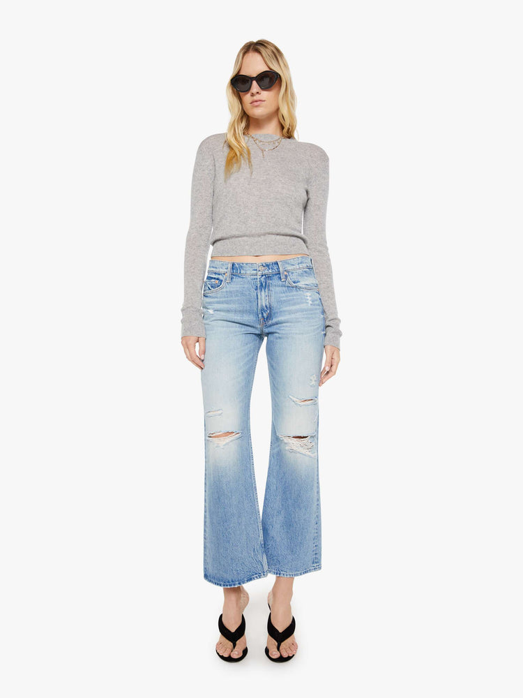 Front view of a woman in a grey sweater is designed with ribbed hems and a cropped fit.