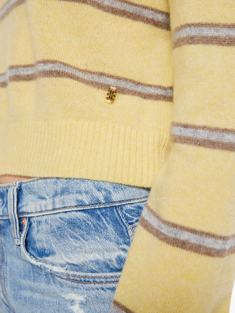 Swatch view of a woman in a butter yellow sweater with horizontal blue stripes, the sweater is designed with a buttoned neck, long sleeves, ribbed hems and a cropped fit. 