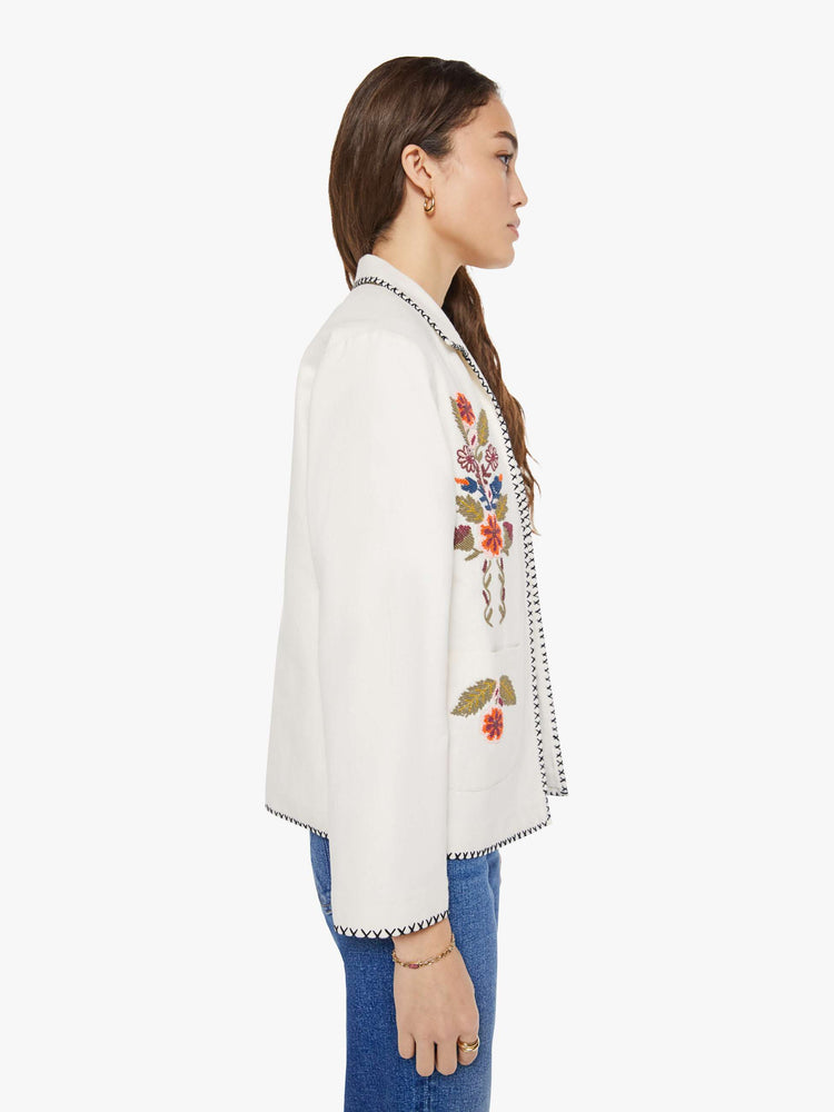 Side view of a woman in a slightly dropped shoulders jacket, front patch pockets and a tailored fit that hugs the body like a blazer.