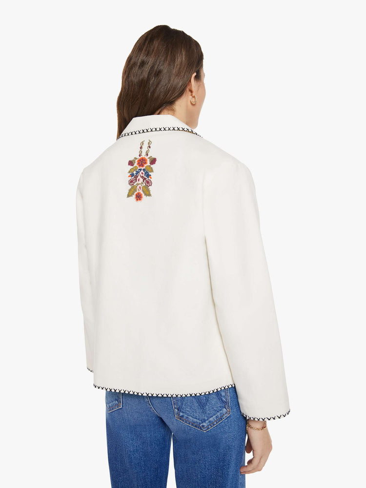Back view of a woman in a slightly dropped shoulders jacket, front patch pockets and a tailored fit that hugs the body like a blazer.