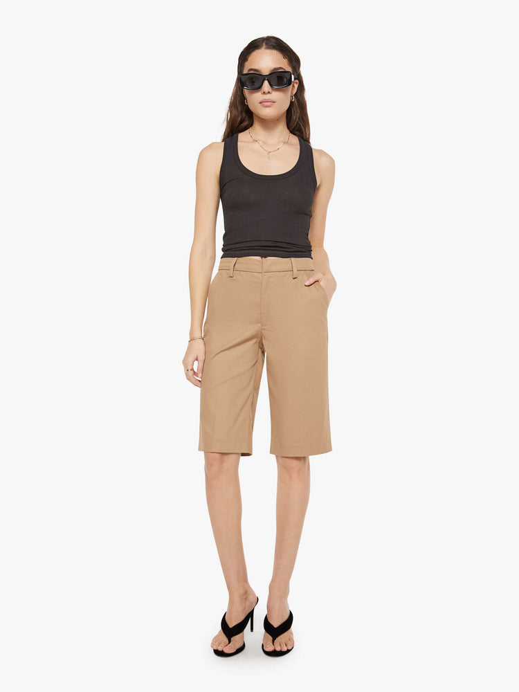 Front view of a woman in Bermuda trousers from the Los Angeles brand SPRWMN (pronounced "superwoman") have a high rise, slit pockets and knee-length inseam.