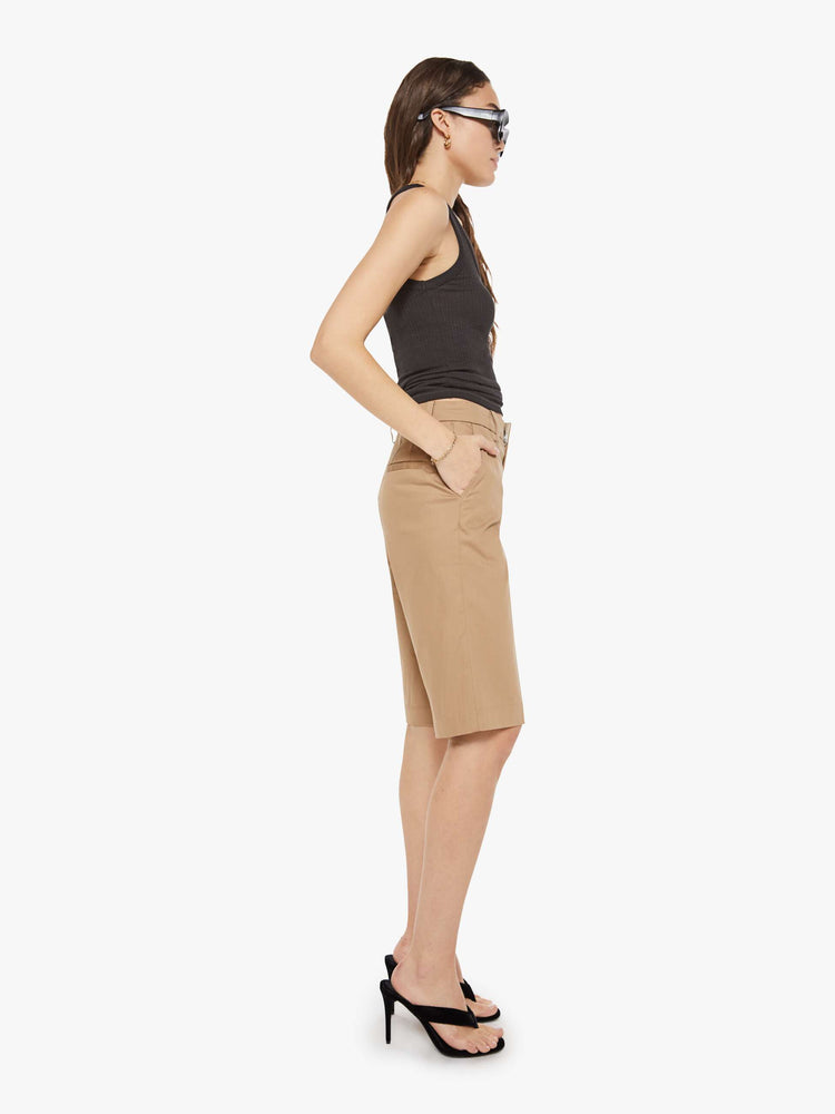 Side view of a woman in Bermuda trousers from the Los Angeles brand SPRWMN (pronounced "superwoman") have a high rise, slit pockets and knee-length inseam.