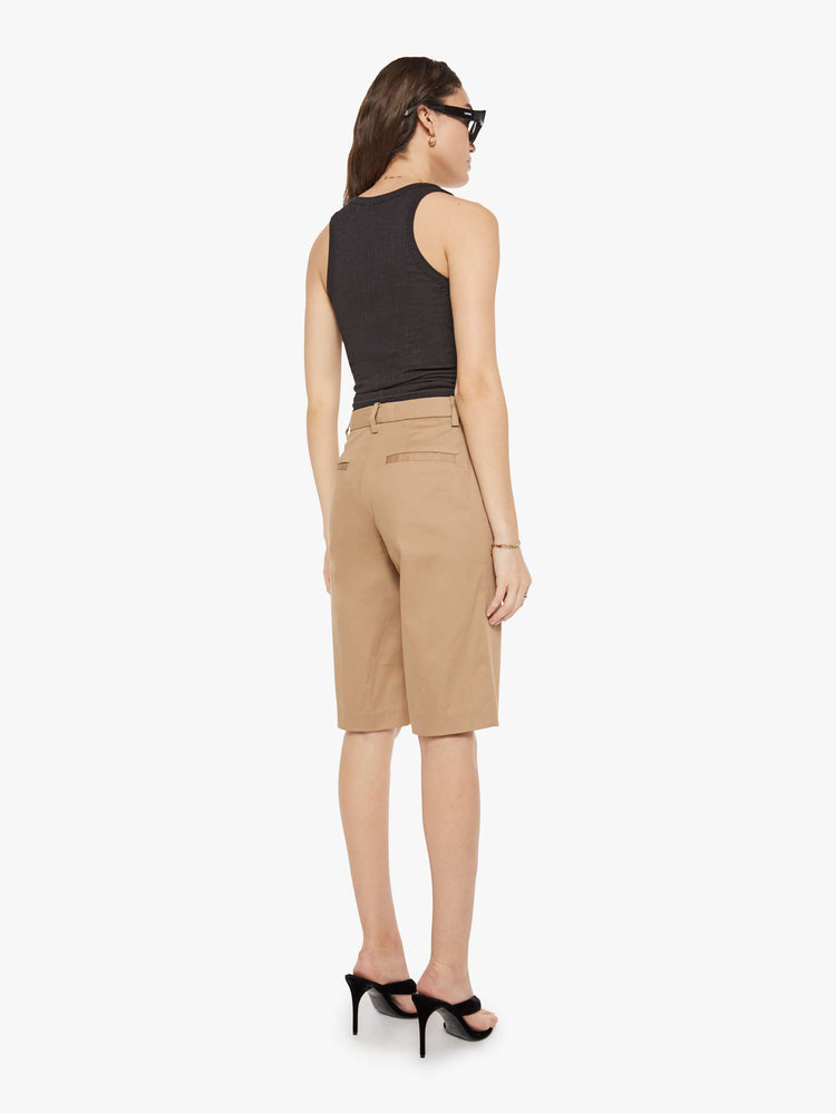 Back view of a woman in Bermuda trousers from the Los Angeles brand SPRWMN (pronounced "superwoman") have a high rise, slit pockets and knee-length inseam.