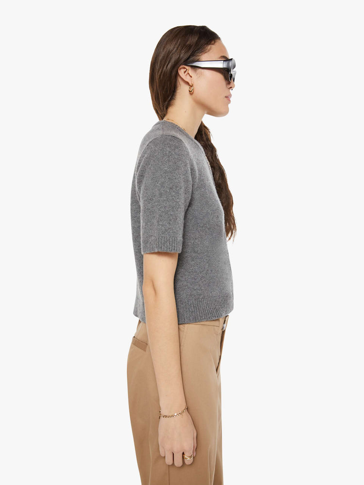 Side view of a woman in short-sleeve cardigan from the Los Angeles brand SPRWMN (pronounced "superwoman") Made from 100% cashmere in grey, the sweater has a crewneck and a slightly cropped fit.