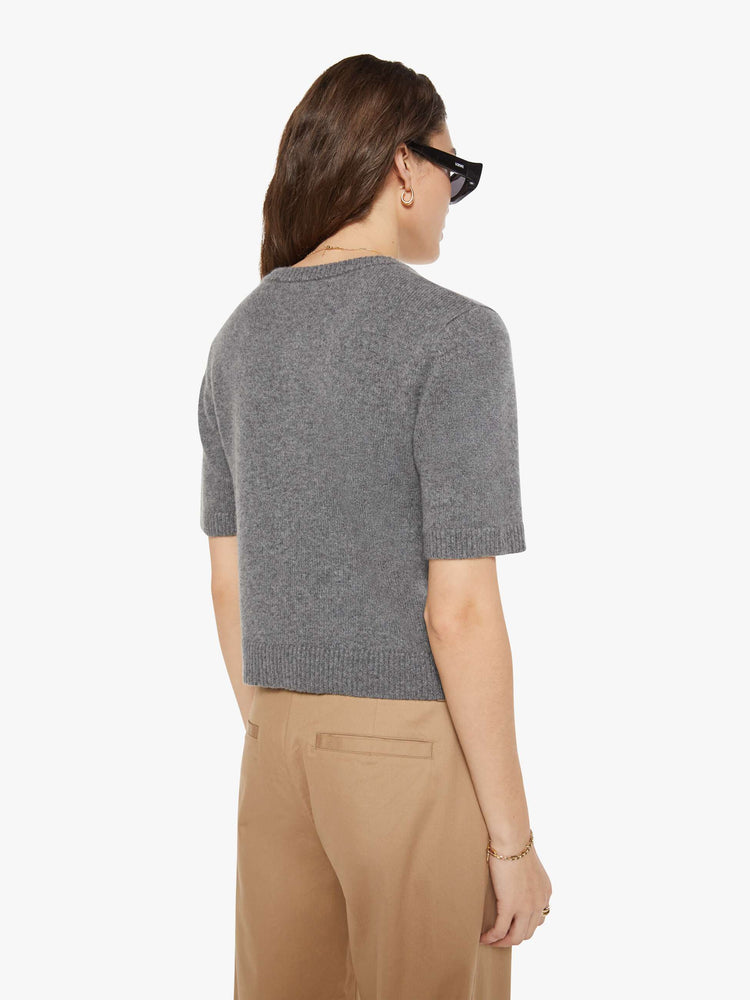 Back view of a woman in short-sleeve cardigan from the Los Angeles brand SPRWMN (pronounced "superwoman") Made from 100% cashmere in grey, the sweater has a crewneck and a slightly cropped fit.