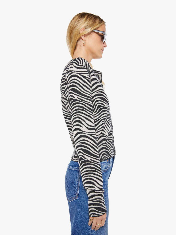 Side view of a woman in a  zebra print cardigan.