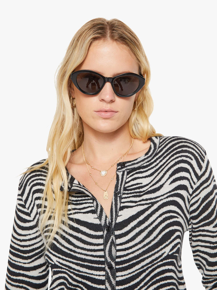 Close up view of a woman in a  zebra print cardigan.
