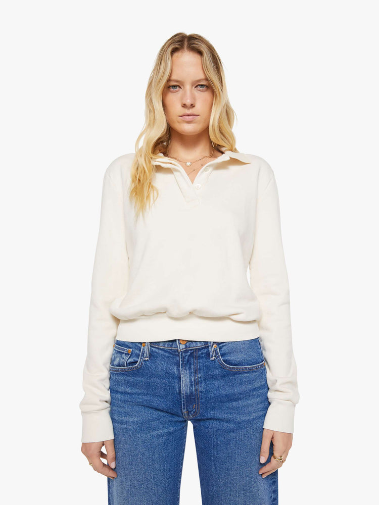 Front view of a woman in a cream  with a collared neck, ribbed hems and a comfortable fit. 