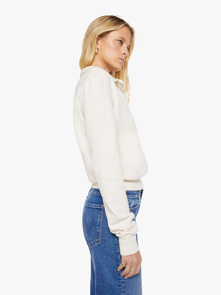 Side view of a woman in a cream  with a collared neck, ribbed hems and a comfortable fit. 