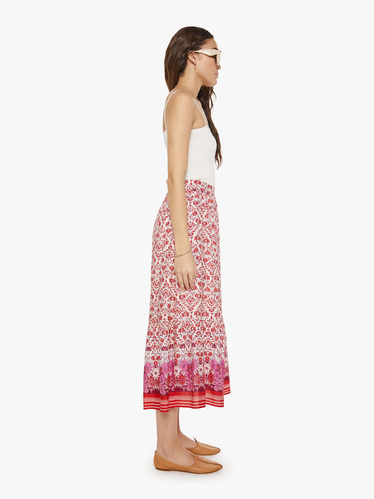 Side view of a woman in a cream and pink graphic print  with a high rise and a loose, straight fit. 