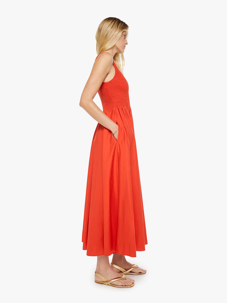 Side view of a woman in bright red sleeveless midi dress.