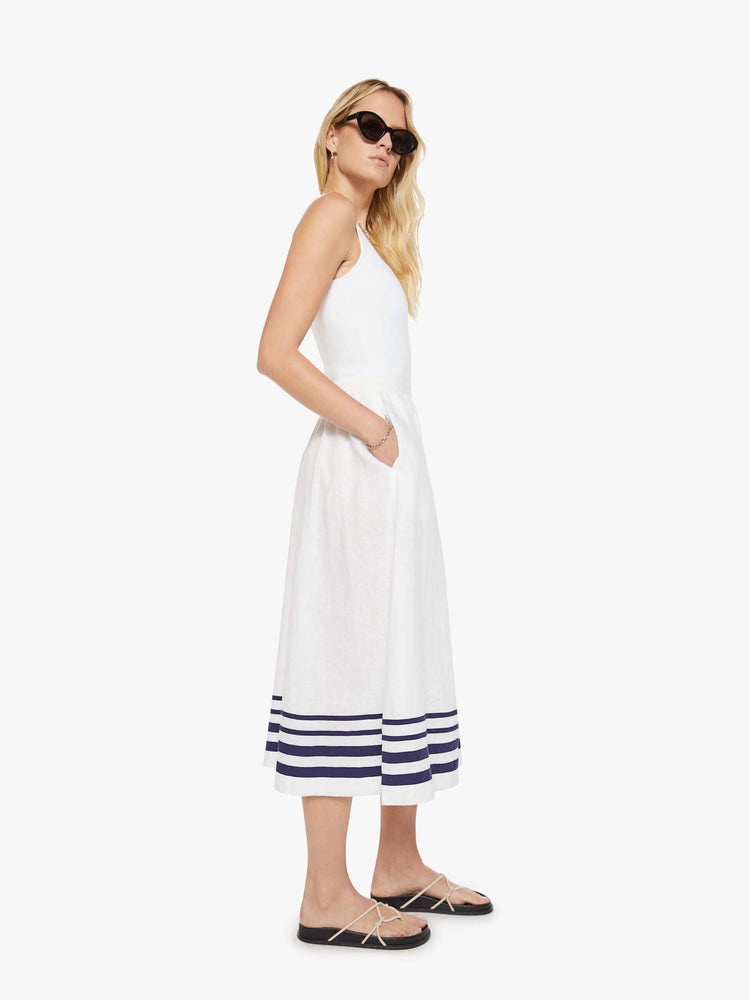 Side view of a woman in a white with navy stripes with a high rise, slit pockets and a loose, flowy fit.