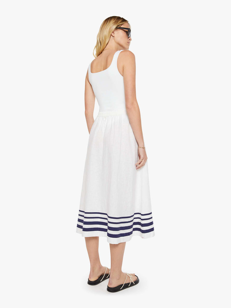 Back view of a woman in a white with navy stripes with a high rise, slit pockets and a loose, flowy fit.