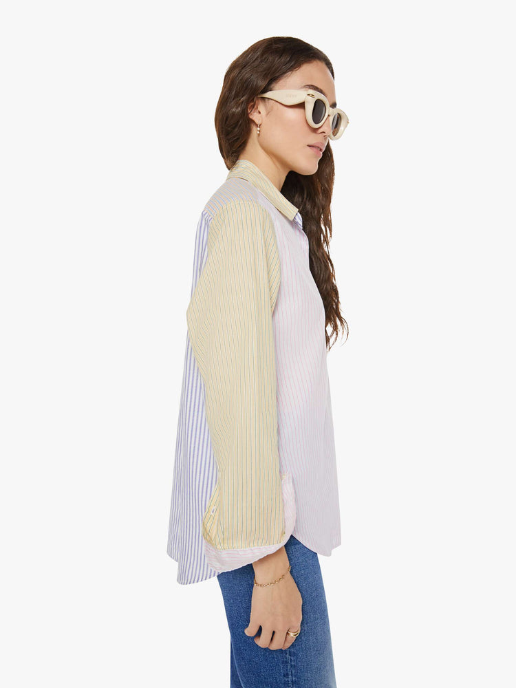 Side view of a woman in sage green and light blue striped button-down.
