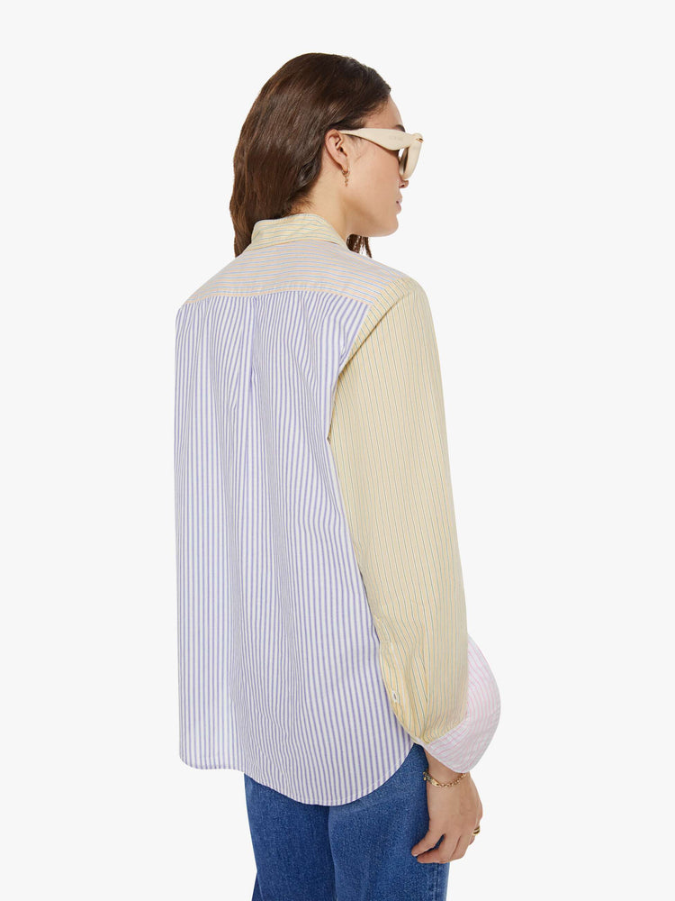 Back view of a woman in sage green and light blue striped button-down.