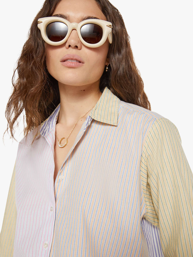 Close up view of a woman in sage green and light blue striped button-down.