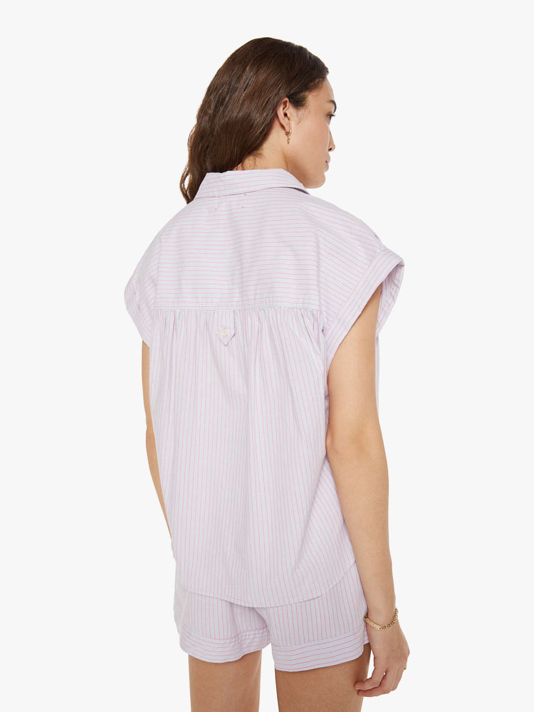 Back view of a woman in a pink and grey stripe sleeveless button-down shirt.