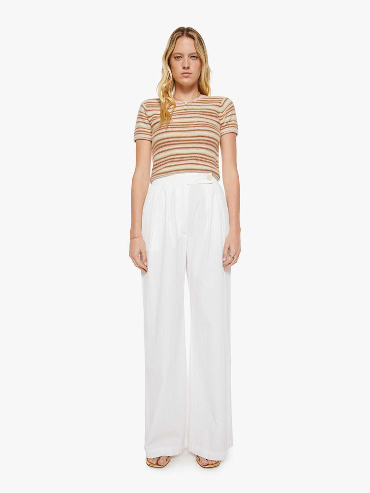 Full body view of a woman in a warm-toned stripes, the Jude tee is designed with a crewneck, short sleeves and a slightly shrunken fit.