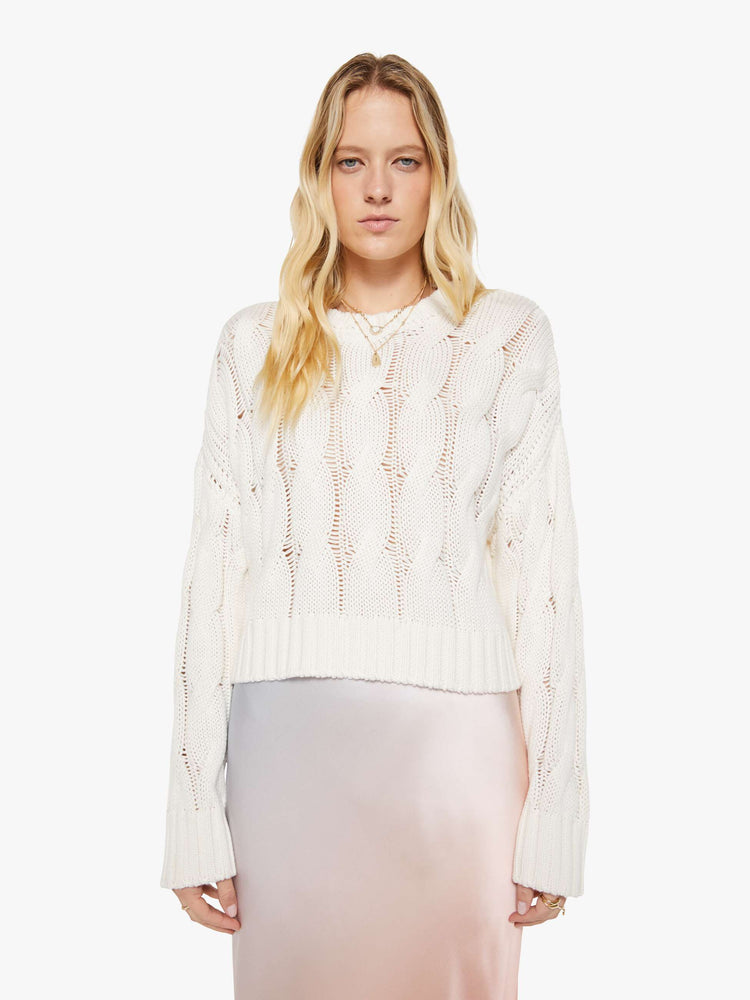 Front view of a woman in a  top is designed with a crewneck, long sleeves, ribbed hems and a slightly oversized fit.